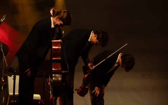Das Trio Jaspard Hatzfeld Prechal tritt unter dramatischer Beleuchtung beim meetMUSIC Open Air auf.
